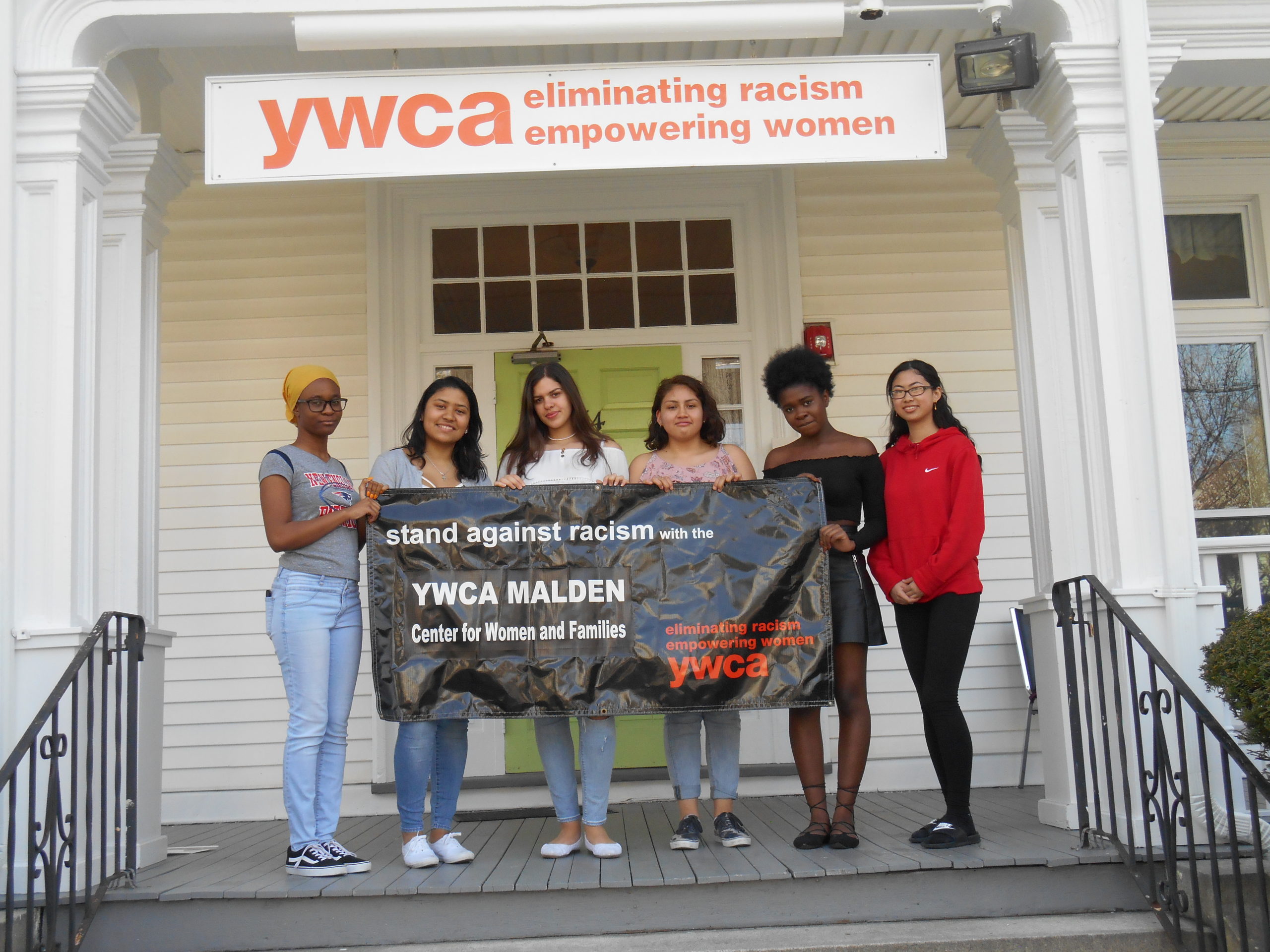 Photo of a group of young women holding a YWCA Malden sign