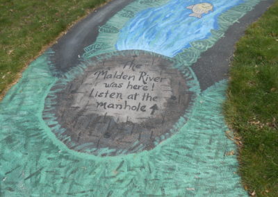 Image of sidewalk painting of a manhole indicating where the malden river used to flow